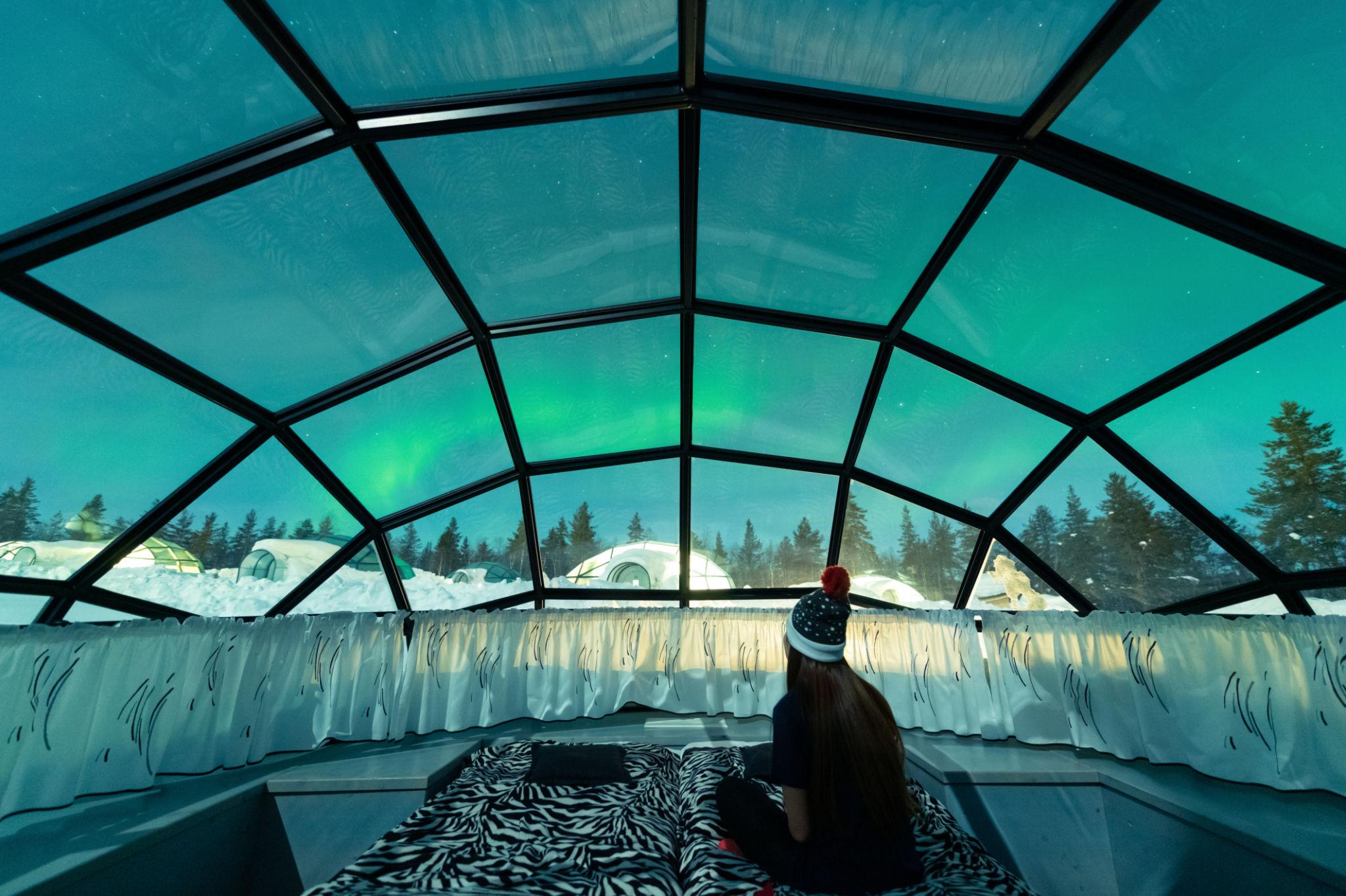 View of the Aurora borealis shining in the night sky seen from Glass Igloos - Finland eSim