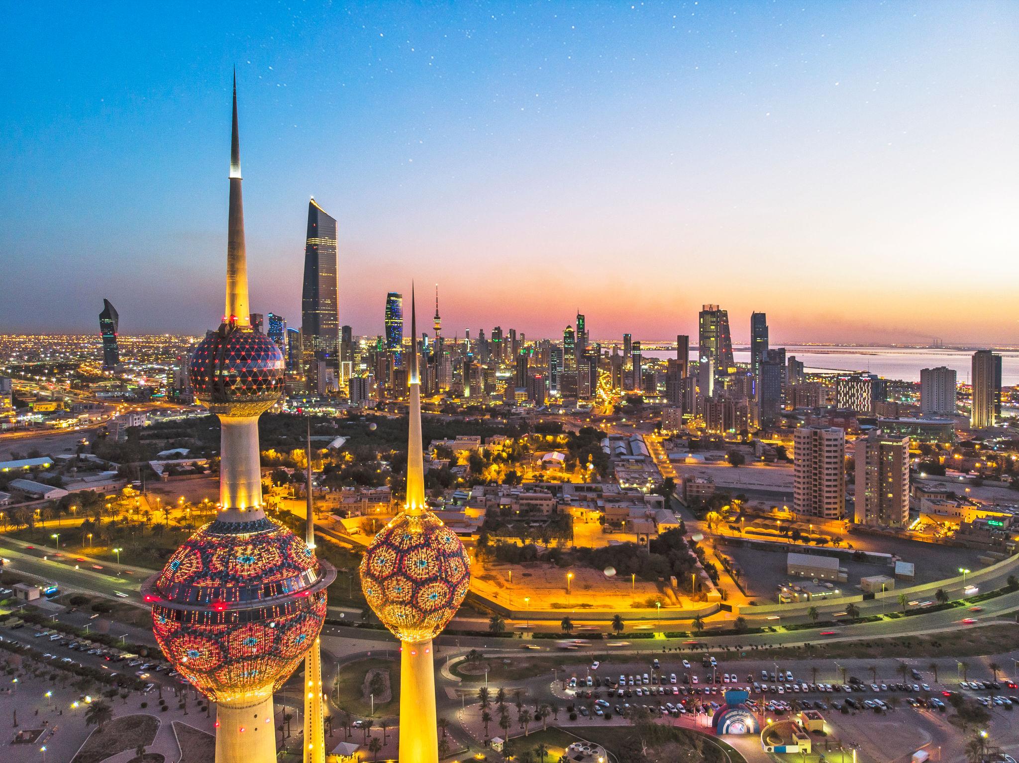 View of the An aerial shot of the Kuwait Towers during sunset with the view of the skyscrapers at the background - Kuwait eSim